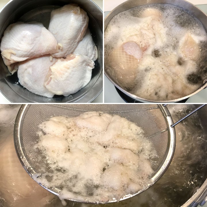 Fresh chicken pieces being boiled in a pot with water and a skimmer removing foamy scum