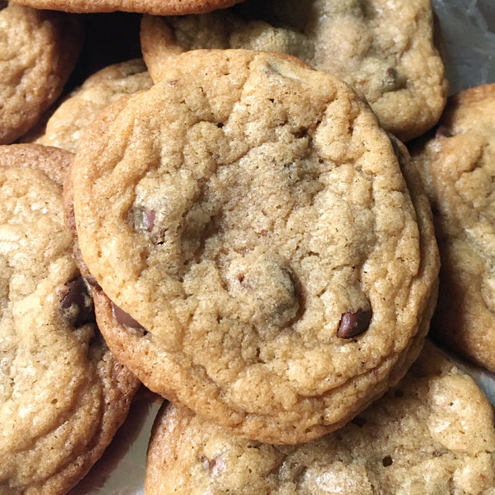 Close-up of a chocolate chip cookie on top of a pile of cookies