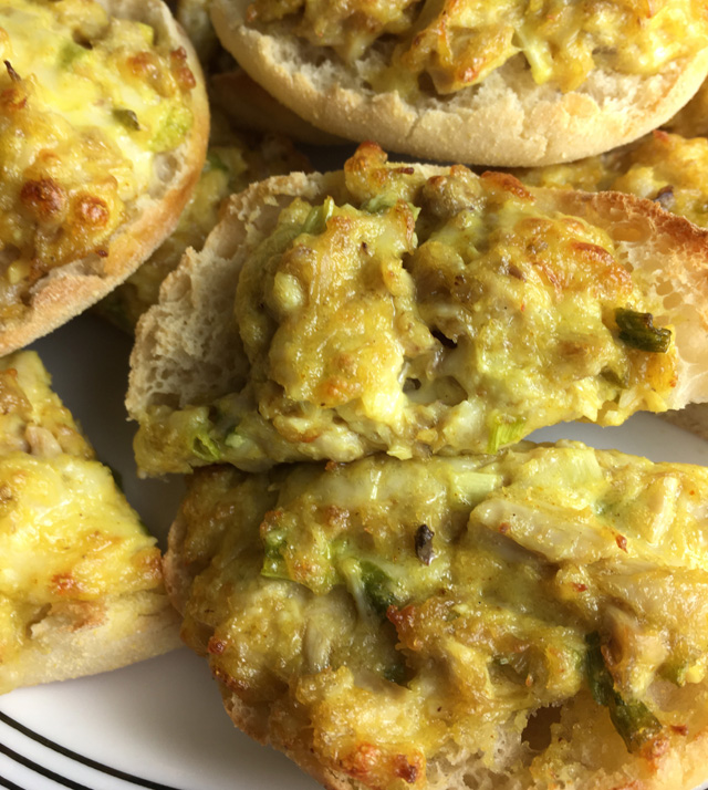 A white plate of English muffins topped with curry chicken for Curry Chicken Canapes