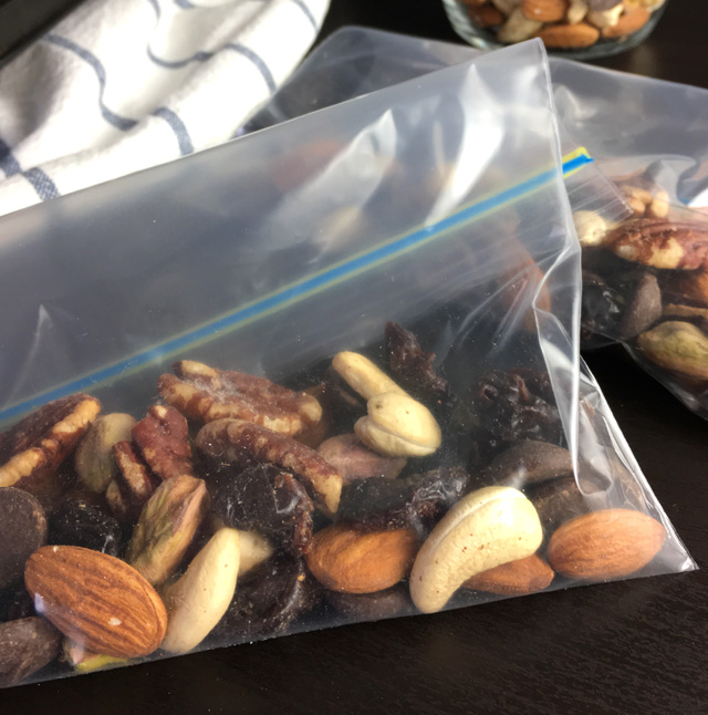 DIY Salty & Sweet Trail Mix made up of cashews, almonds, pistachios, chocolate chips, pecans, and dried cherries in zip top bags