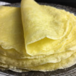 A pile of crepes with one folded over on top