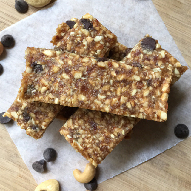 A stack of cashew date bars on parchment