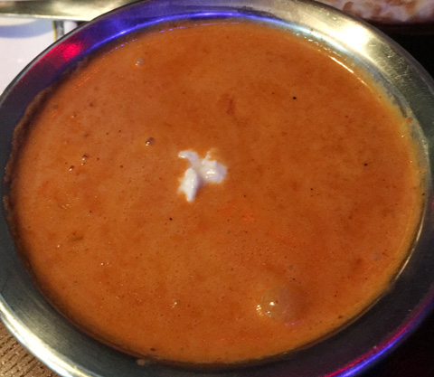 A metal bowl filled with Butter Chicken at Hungry Eye Restaurant and Bar