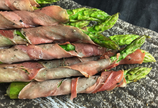 Prosciutto Wrapped Asparagus on a grey platter