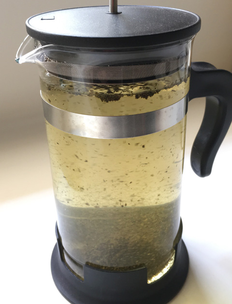 Water and loose tea leaves in a French press carafe for making Cold Brewed Tea