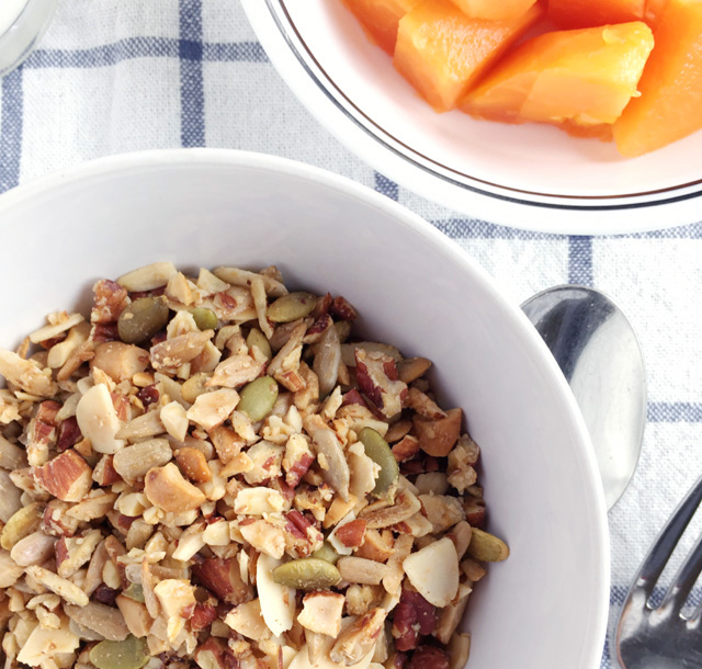 A bowl of Easy Grain Free Nutty Granola and a bowl of cut papaya