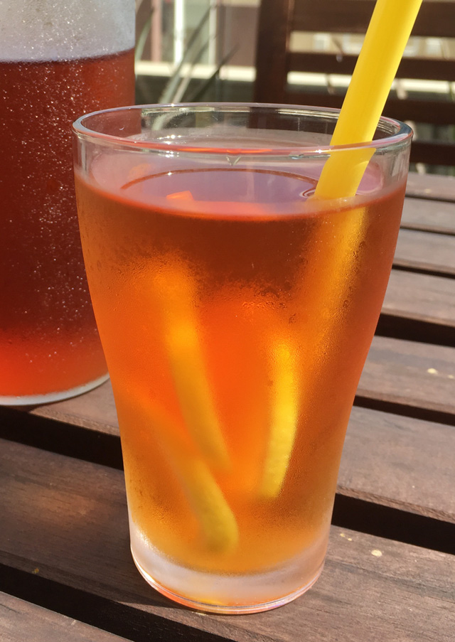 A glass of Cold Brewed Tea with lemon slices and a straw