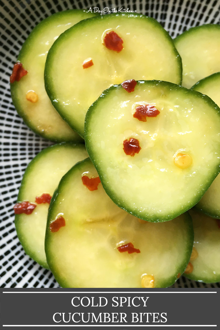 Close-up of several slices of cucumbers with red chili flakes in a round bowl, the words cold spicy cucumber bites on the bottom