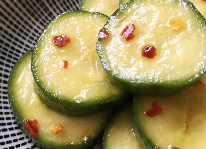 Close-up of thick cucumber slices topped with red chili flakes