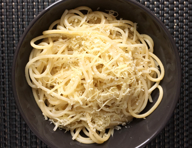 A grey bowl filled containing Simple Parmesan Buttered Pasta with spaghetti
