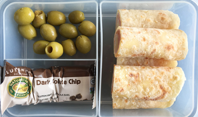 A lunch box containing olives, a granola bar, and wraps using Soft Gluten-Free Tortilla Flatbread