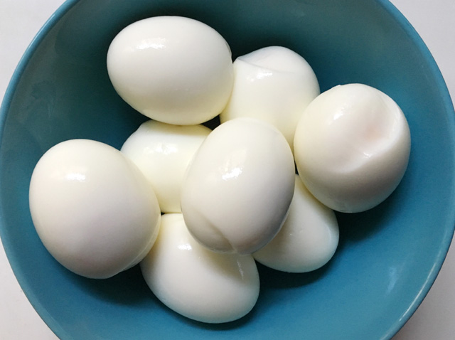 A blue bowl of hard-cooked eggs from Cooking Eggs In A Rice Cooker