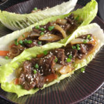 Three Korean Steak Lettuce Wraps on a brown metallic plate
