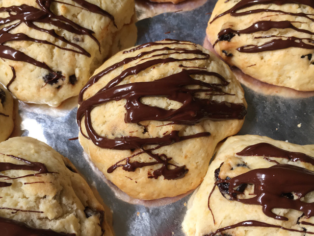 Melted chocolate drizzled on cranberry tea scones