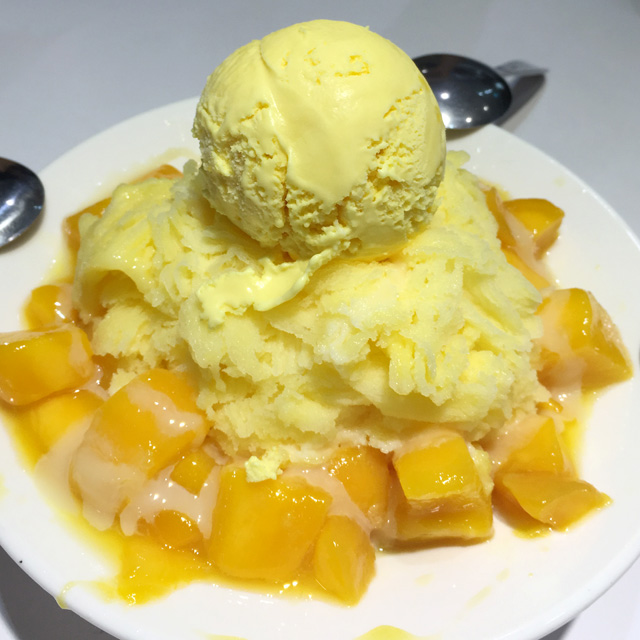 A white bowl containing mango shaved ice, mango ice cream, and fresh mango - eat in Taipei