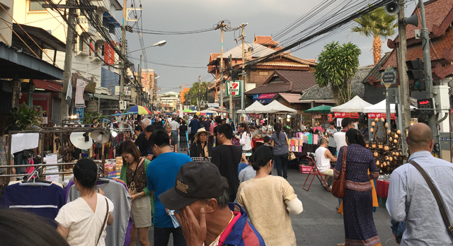 A crowd of people walking the street at the Saturday Night Market in Chiang Mai