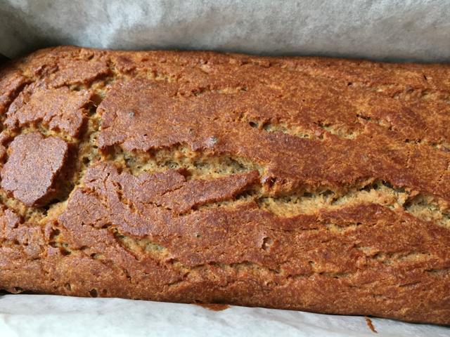Close-up of fresh-baked gluten-free banana bread in a parchment paper lined loaf pan