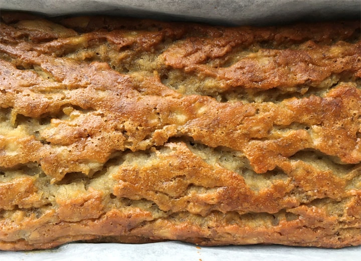 Close-up of a brown loaf of banana bread in a loaf pan