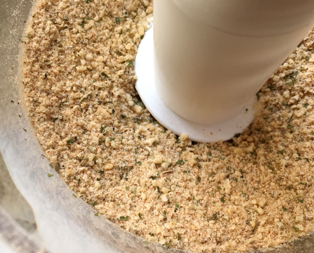 A food processor bowl containing shake n bake seasoning for chicken