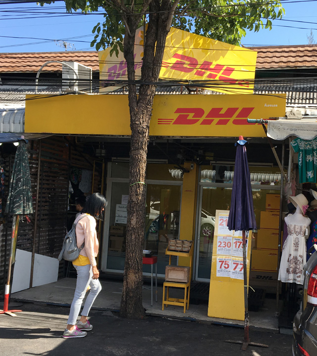 A shopfront with a yellow sign that says DHL