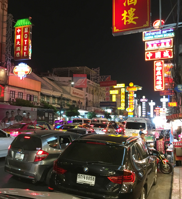 A traffic jam of cars on a street lined with neon signs