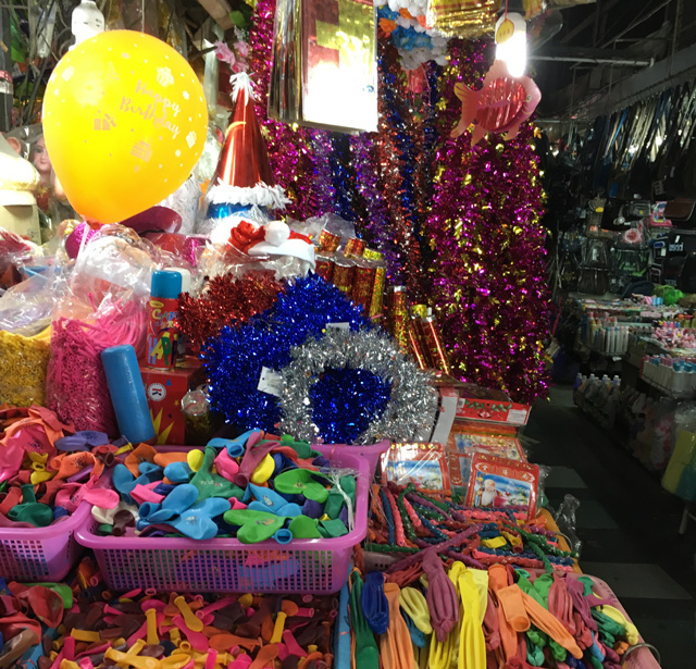 Different colored shiny Christmas garland and baskets of balloons