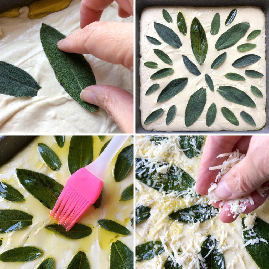 Green leaves on top of white dough in a square pan. Olive oil and grated cheese being spread on top of the leaves.