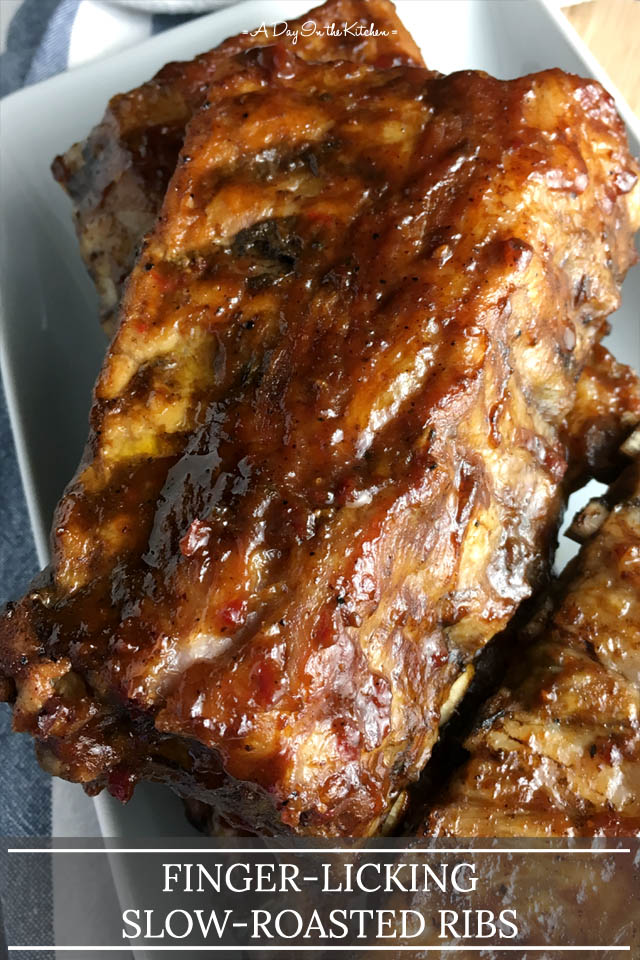 Barbecue sauce glazed pork ribs on a white plate, the words finger-licking slow-roasted ribs at the bottom