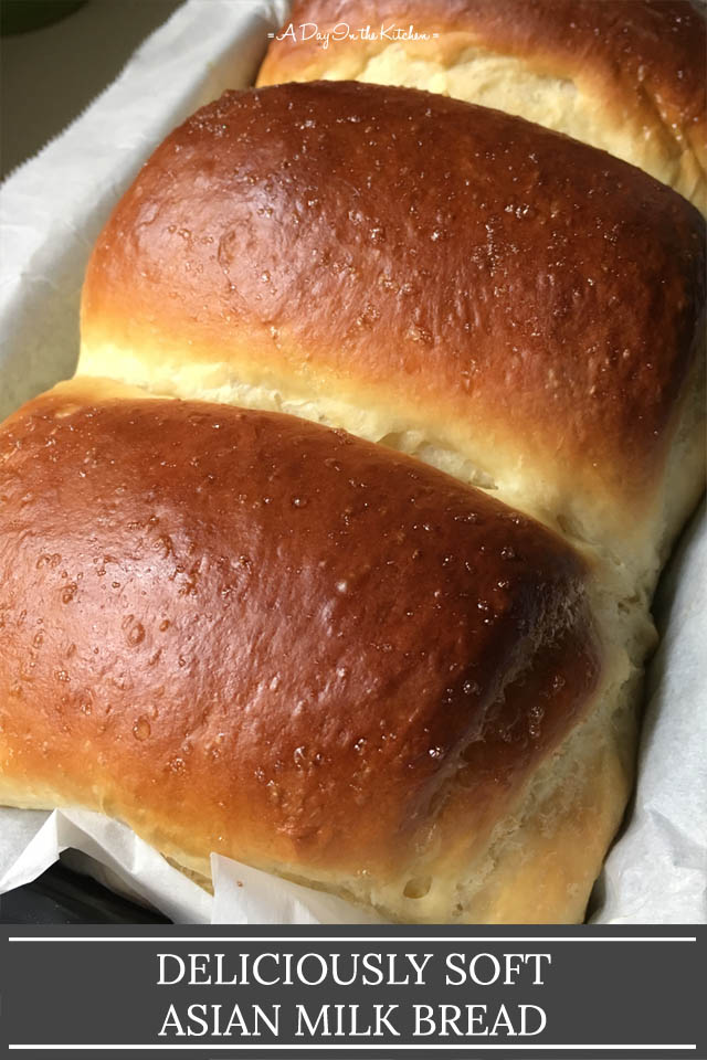 A brown loaf of bread in a paper lined baking pan, the words deliciously soft Asian milk bread on the bottom