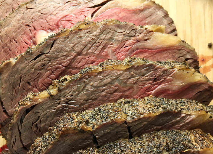 Slices of a beef roast on a wooden cutting board