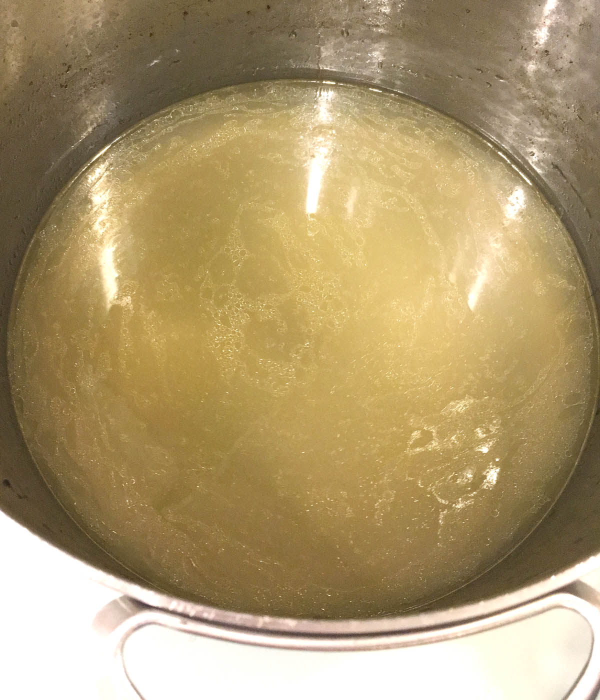 A metal pot containing yellow soup.
