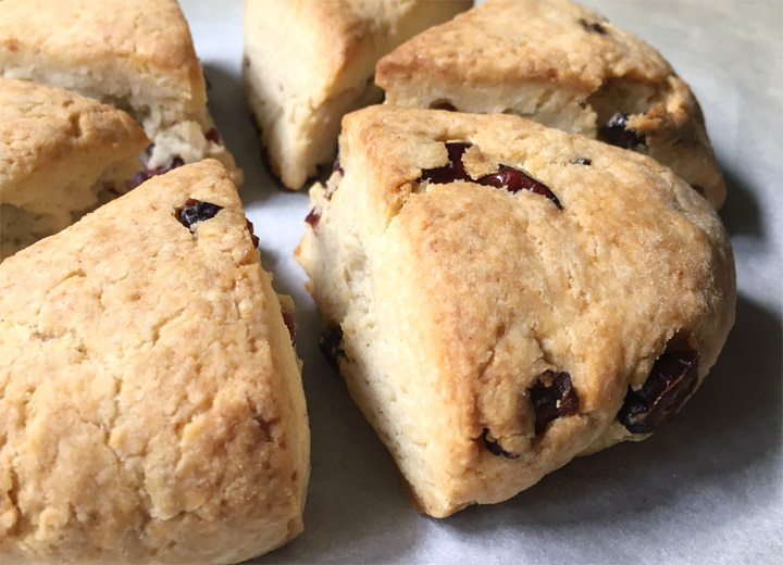 Brown triangle wedge shaped scones on white parchment paper