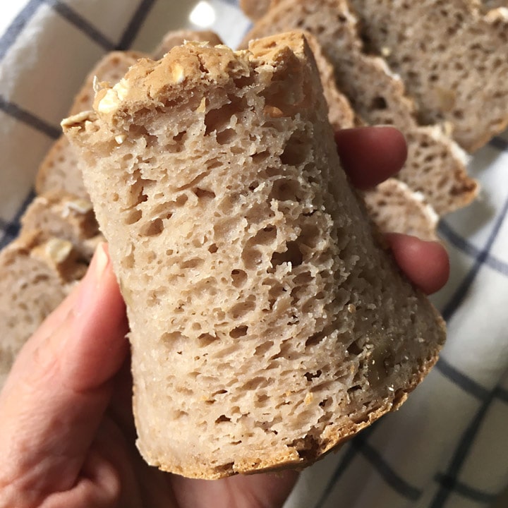 Close-up of a hand bending a slice of brown bread