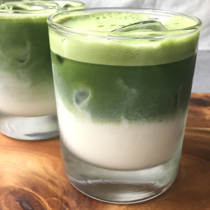 Layers of white and green liquid in short drinking glasses