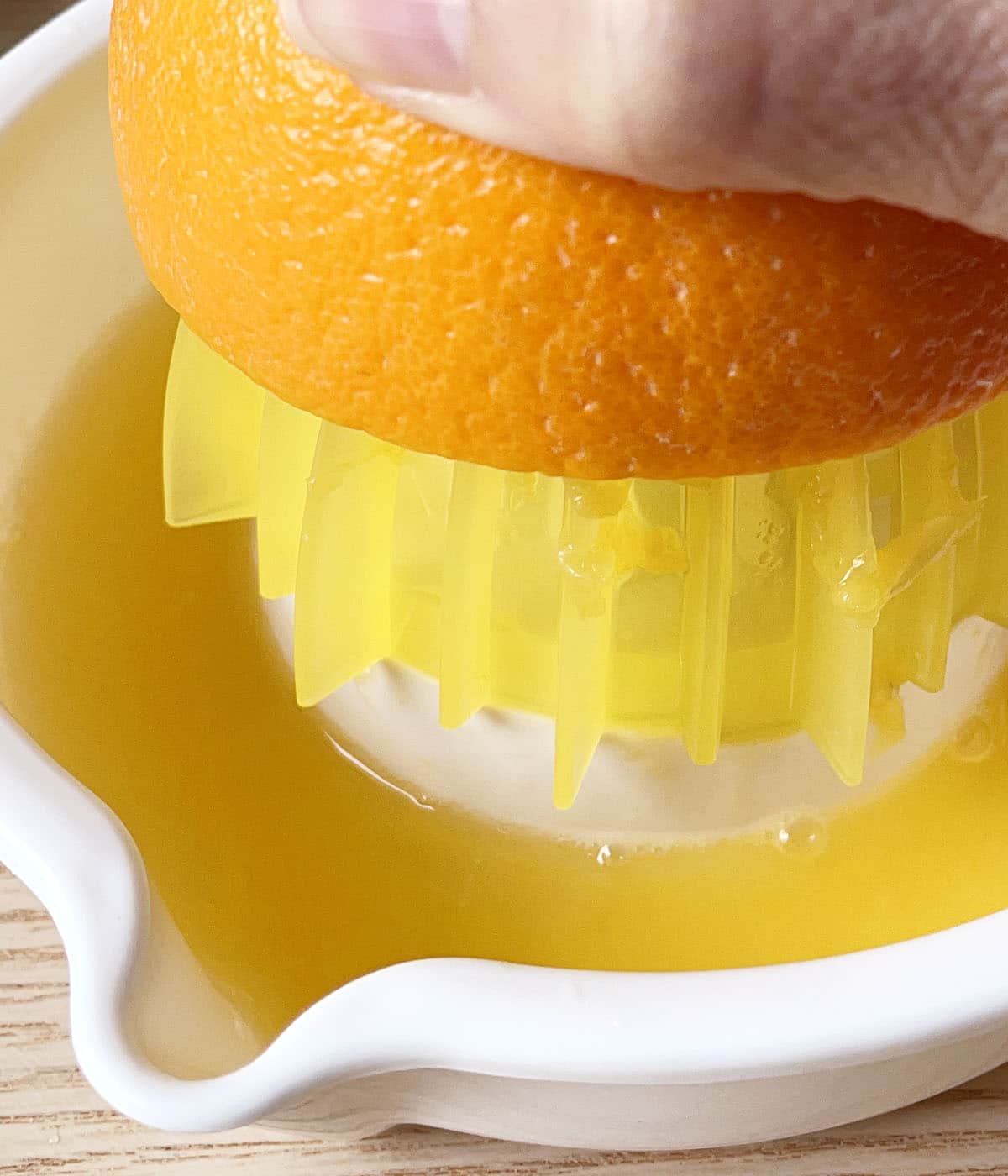 Close-up of a hand juicing half an orange.