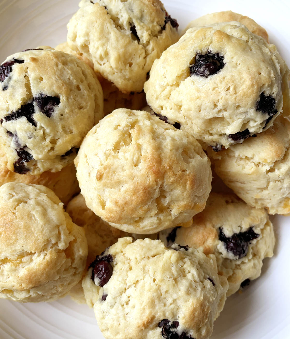 A round white dish containing baked cheese and blueberry tea scones.