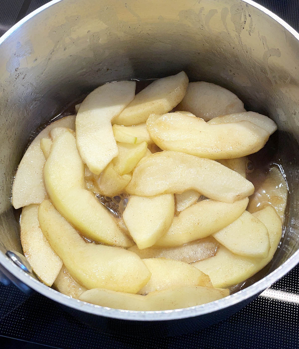 Apple slices in a metal pot.