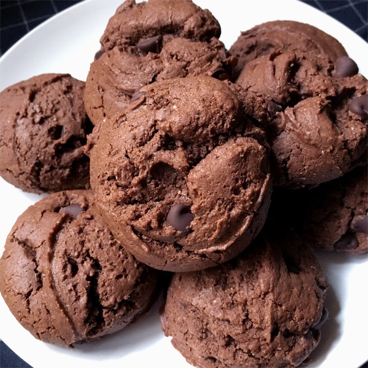 A round white plate containing several brown chocolate chip cookies