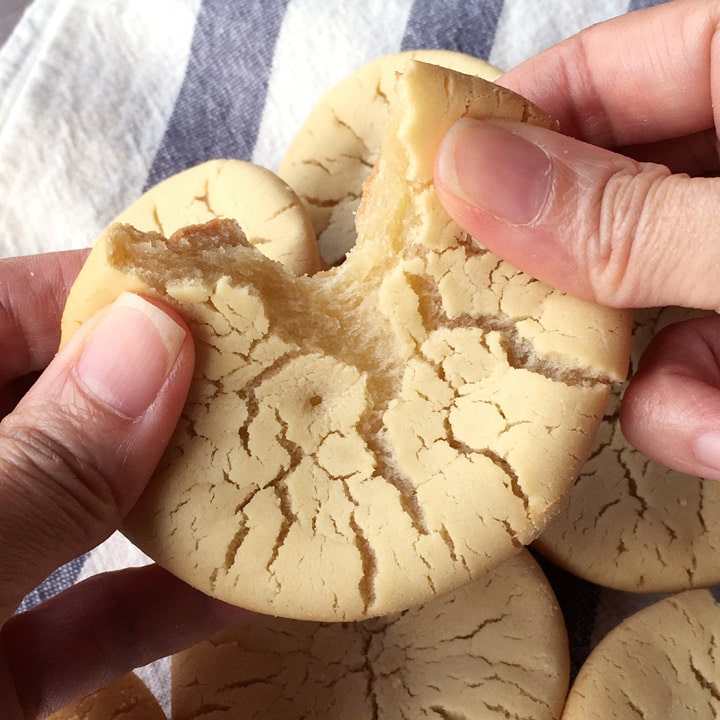 Close-up of two hands ripping apart a butter mochi bite.