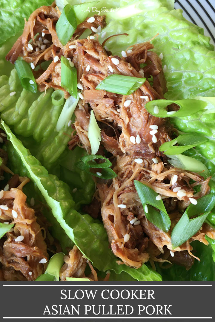Brown pulled pork in green lettuce leaves, topped with chopped green onions and sesame seeds, the words slow cooker Asian pulled pork on the bottom
