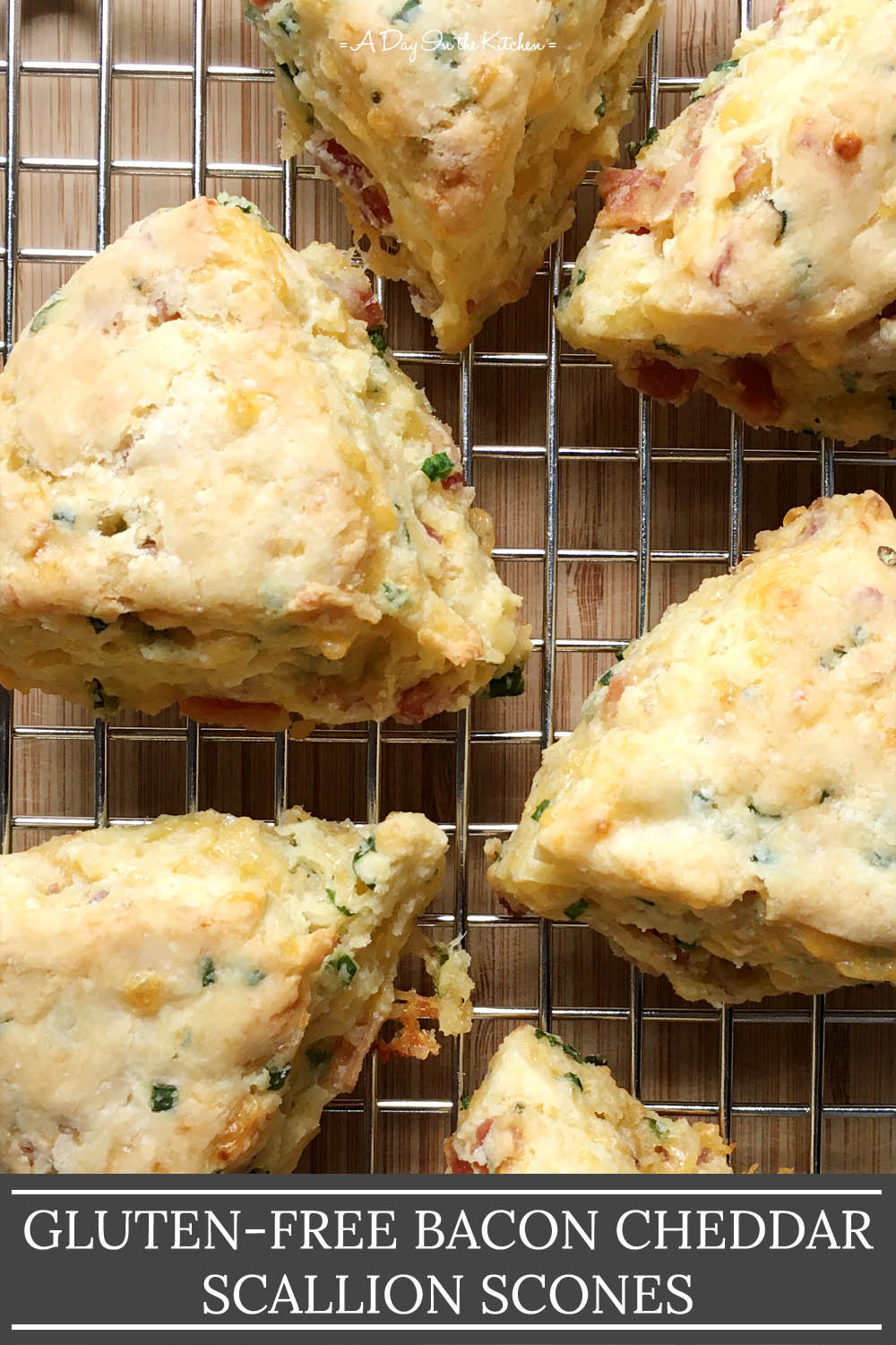 Several triangular shaped scones on a metal rack, the words gluten-free bacon cheddar scallion scones on the bottom.