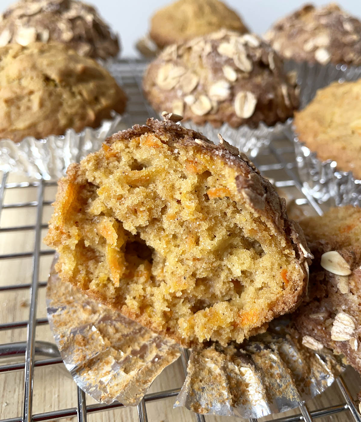 Close-up of the inside of a carrot muffin sitting on a metal rack.