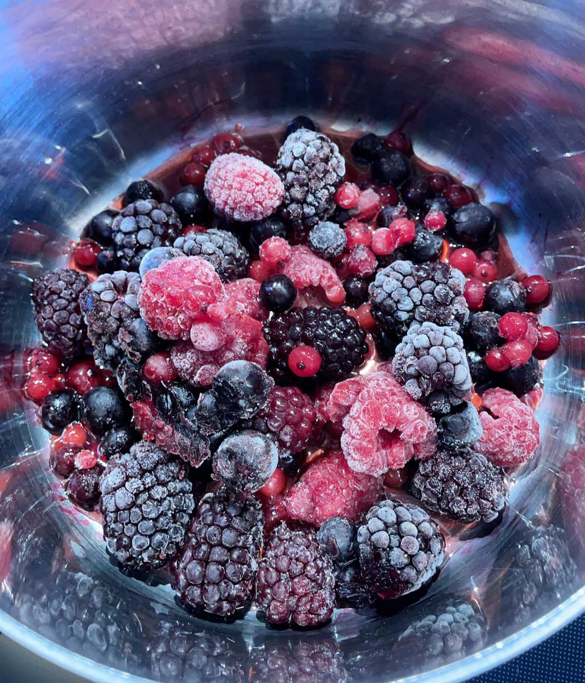 Frozen berries in a round metal pot.