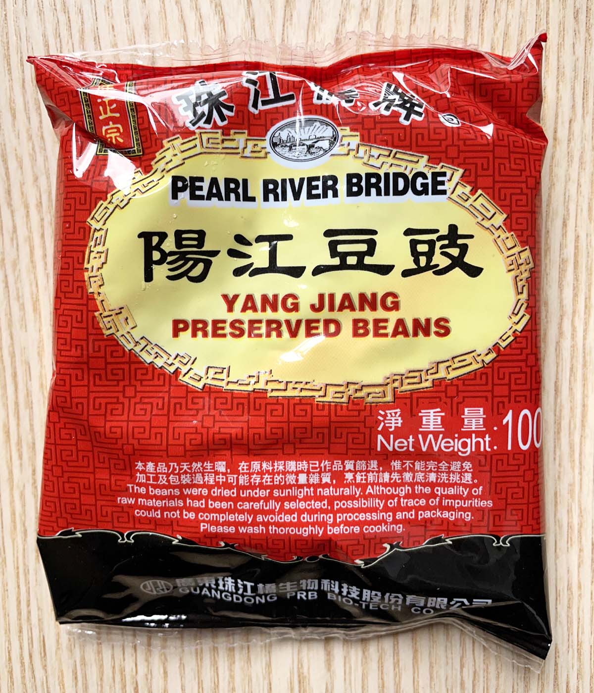 A square red, black, and yellow package of preserved beans.