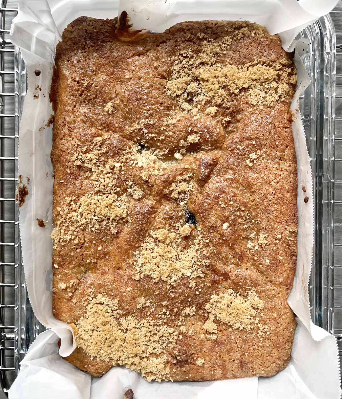 Brown baked cake in a paper-lined rectangular baking dish.