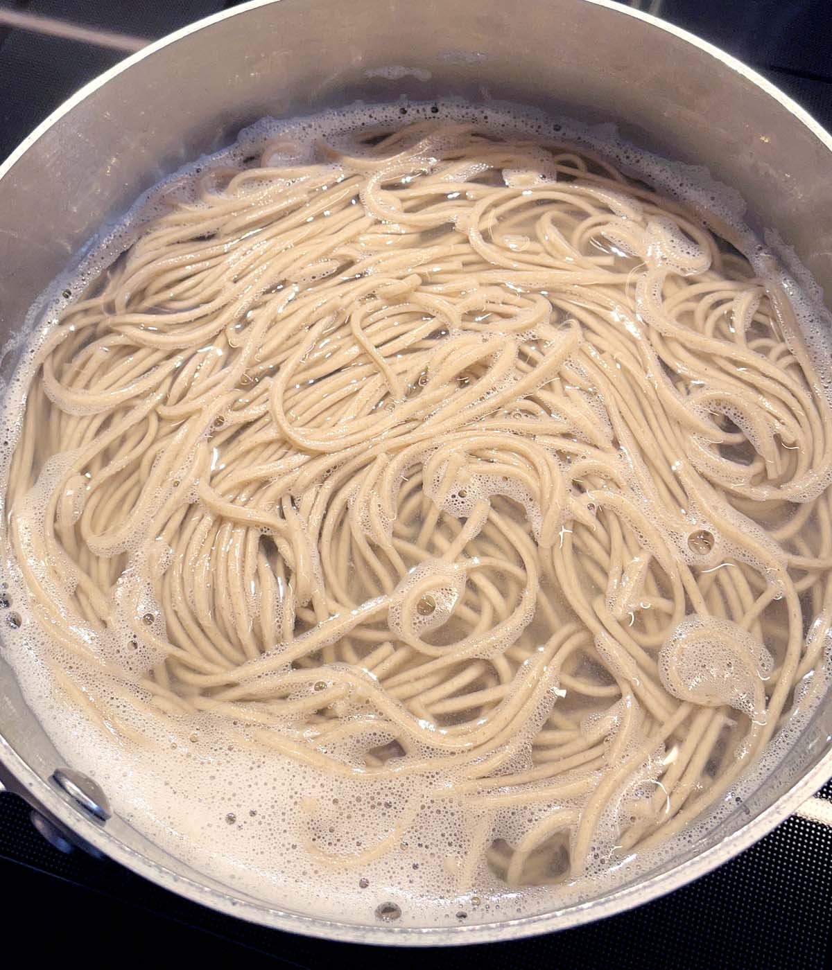 Cooked noodles in a pot with water.